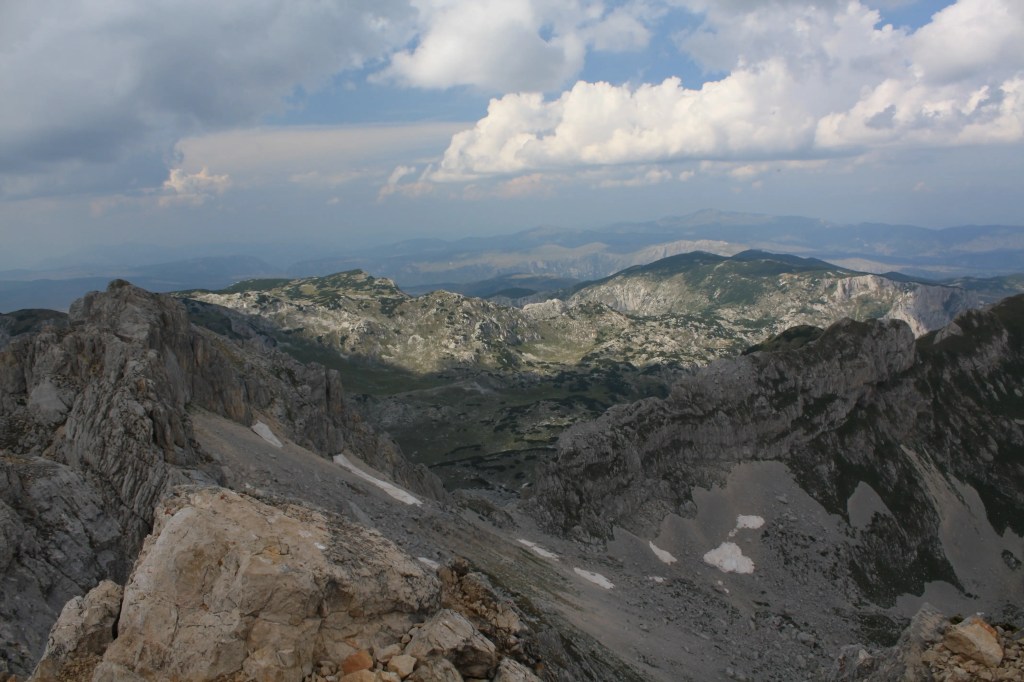 Widok z najwyższego szczytu Czarnogóry, Bobotov Kuk, na rozległe pasmo górskie rozciągające się w dal.