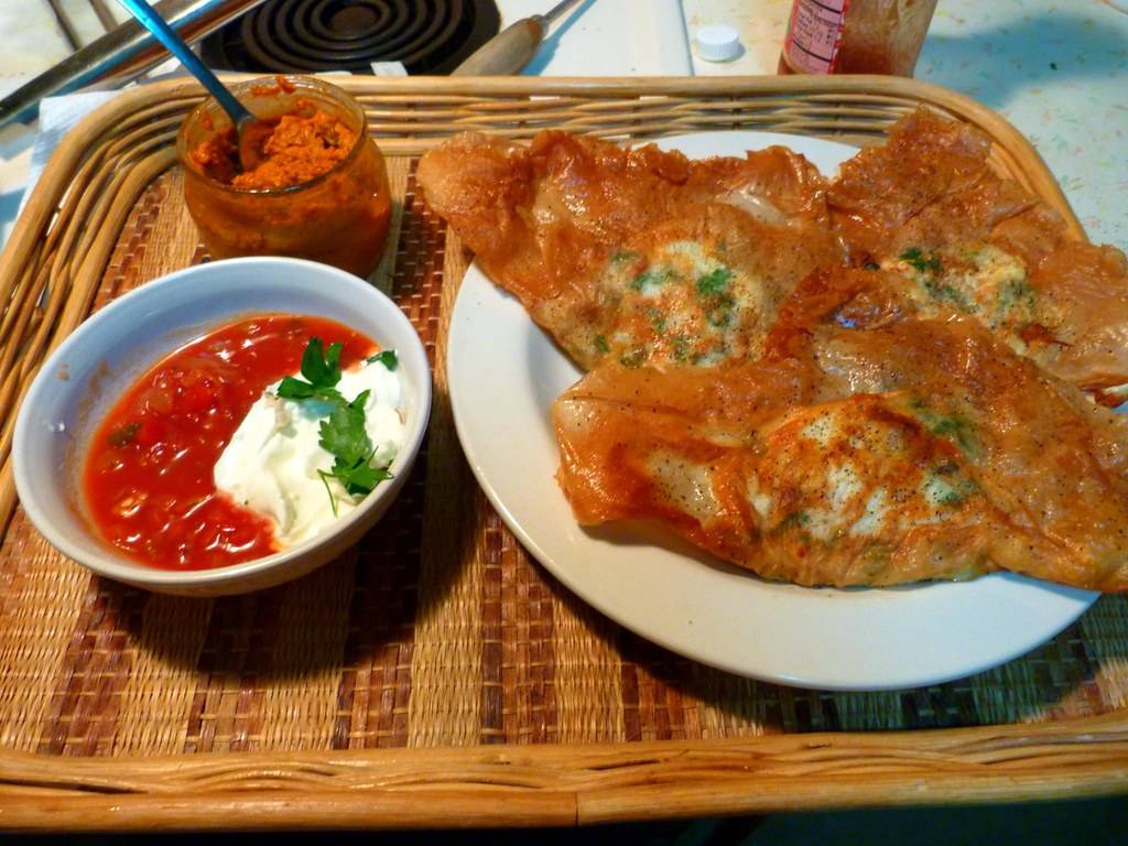 Chrupiący brik z nadzieniem z jajka, tuńczyka i ziemniaków, podany z ostrą pastą harissa, popularna tunezyjska przekąska.