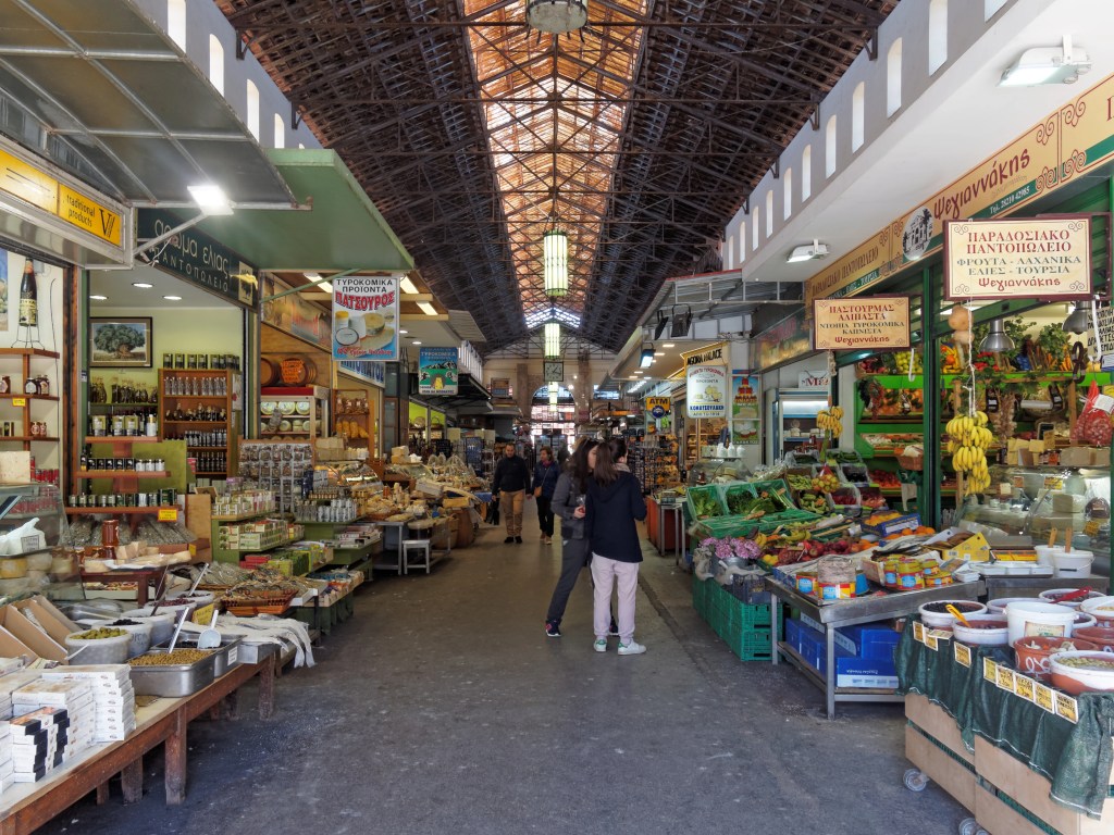 Wnętrze targu Agora w Chanii z licznymi stoiskami z przyprawami i lokalnymi produktami spożywczymi.