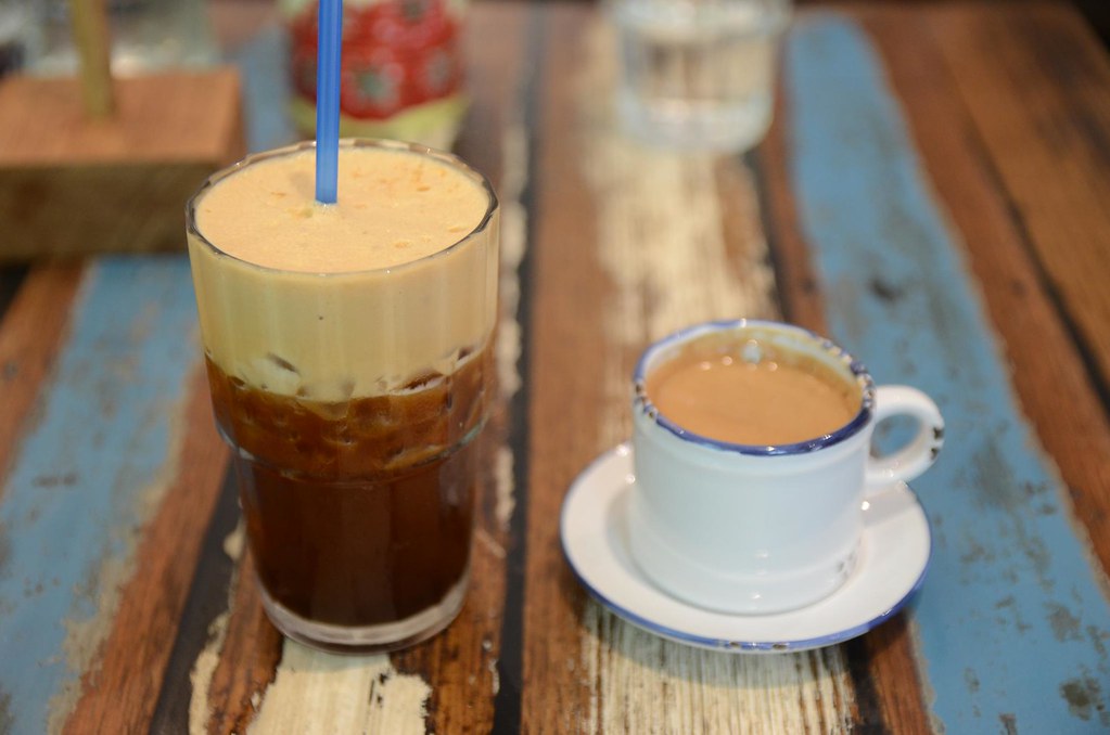 Schłodzone caffe freddo podane w wysokiej szklance obok klasycznego espresso, popularny napój w greckie upały.