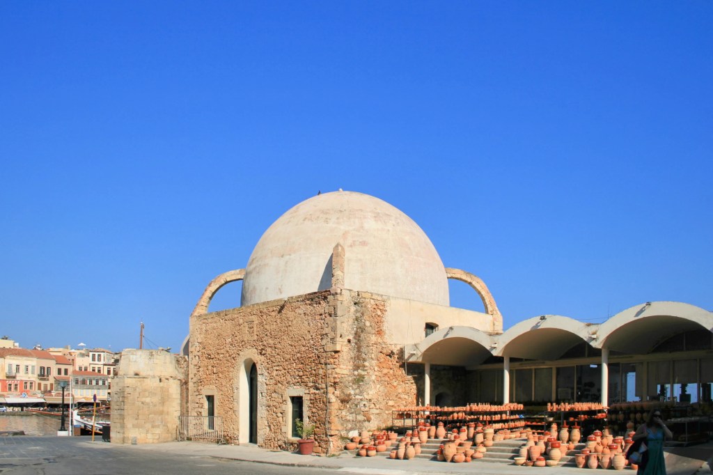 Zabytkowy meczet Janczarów w Chanii, niewielki budynek z charakterystyczną kopułą, położony przy nabrzeżu.