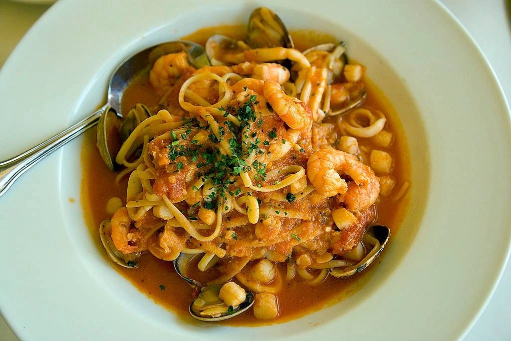 Apetyczny makaron z owocami morza, podany z aromatycznym sosem i świeżymi ziołami.