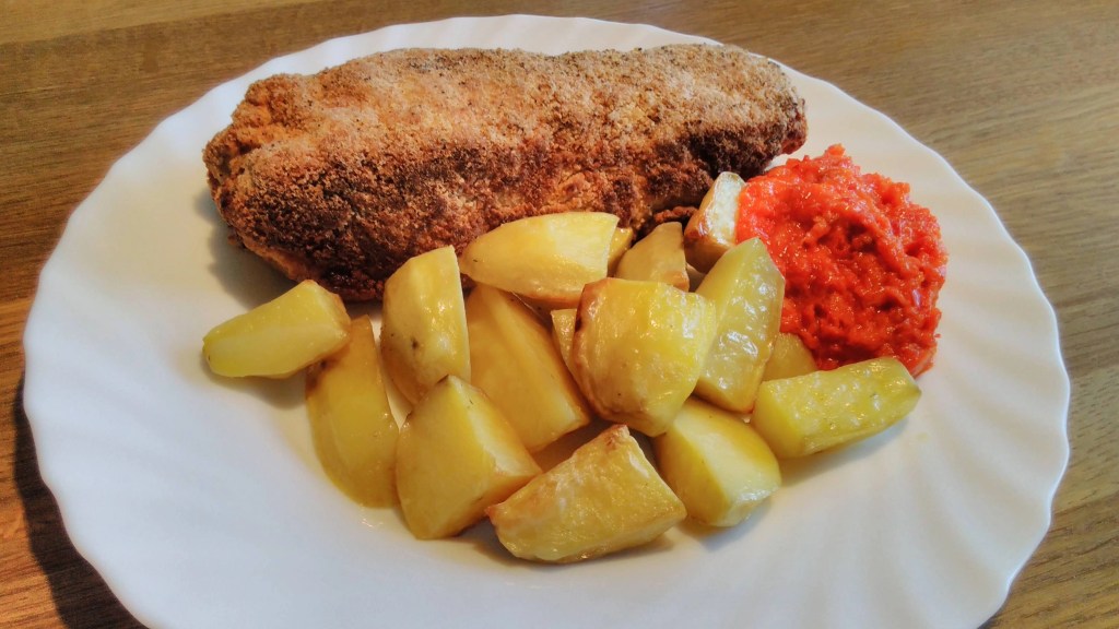 Karađorđeva šnicla podana z ziemniakami i ostrym sosem, tradycyjne danie kuchni bałkańskiej.