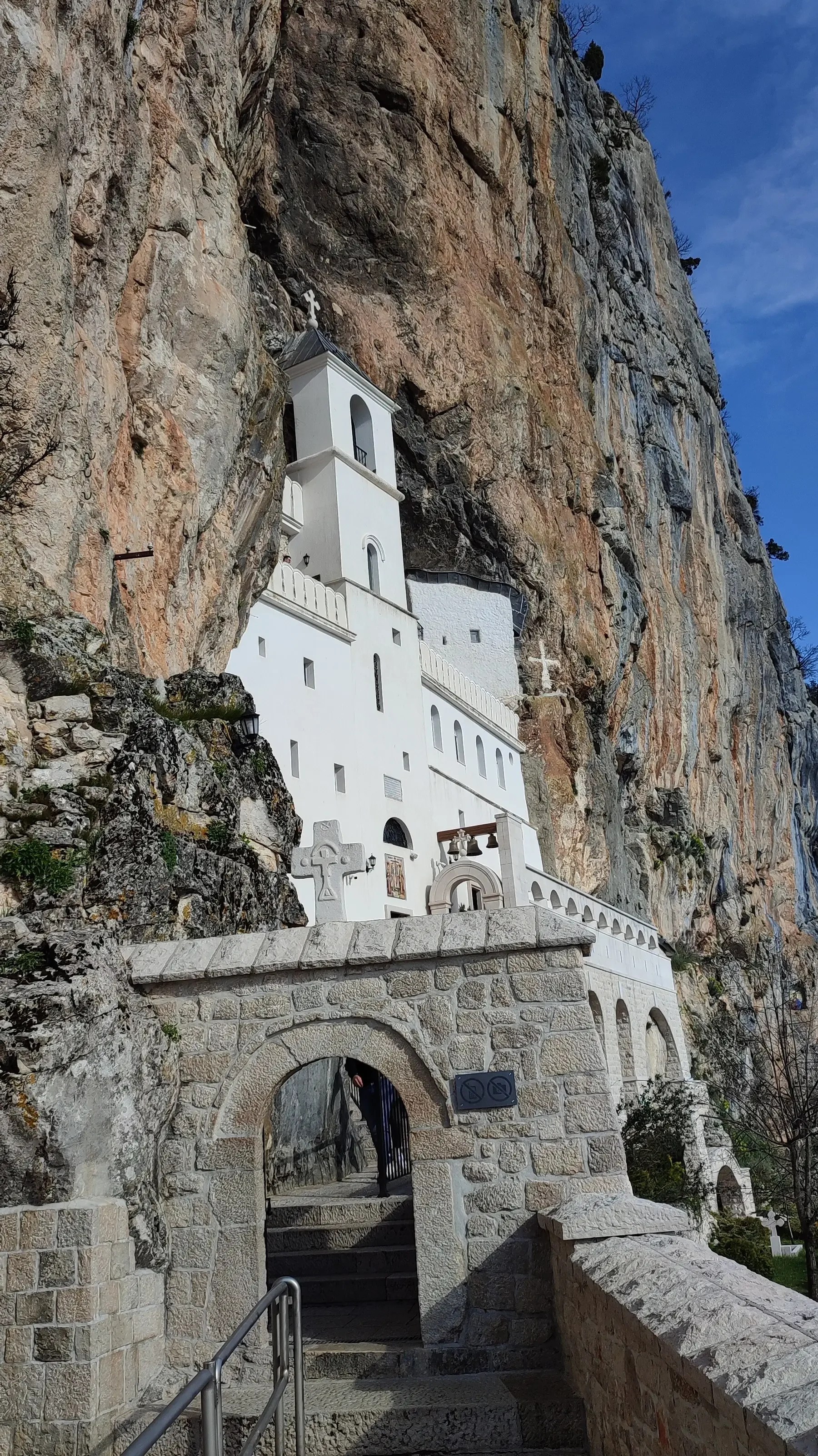 Biały klasztor Ostrog wbudowany w stromą skalną ścianę, ważne miejsce pielgrzymkowe w Czarnogórze.