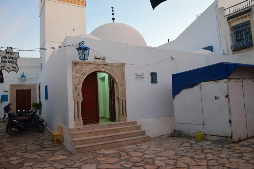 ChatGPT powiedział:
Meczet w Hammamecie z białymi ścianami i otwartymi drzwiami, ukazujący prostą i spokojną architekturę.