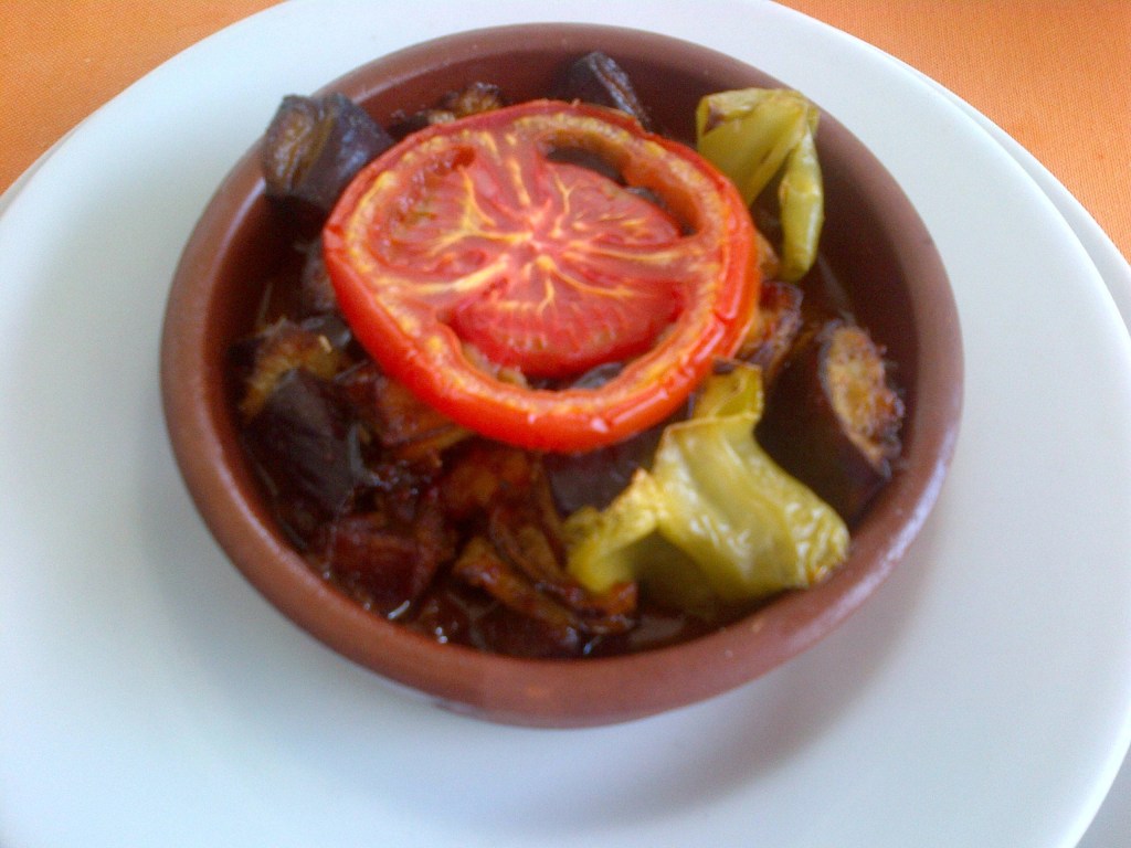 Sataraš – bałkańskie leczo z plasterkiem pomidora i grillowanymi papryczkami na wierzchu jako dekoracja.