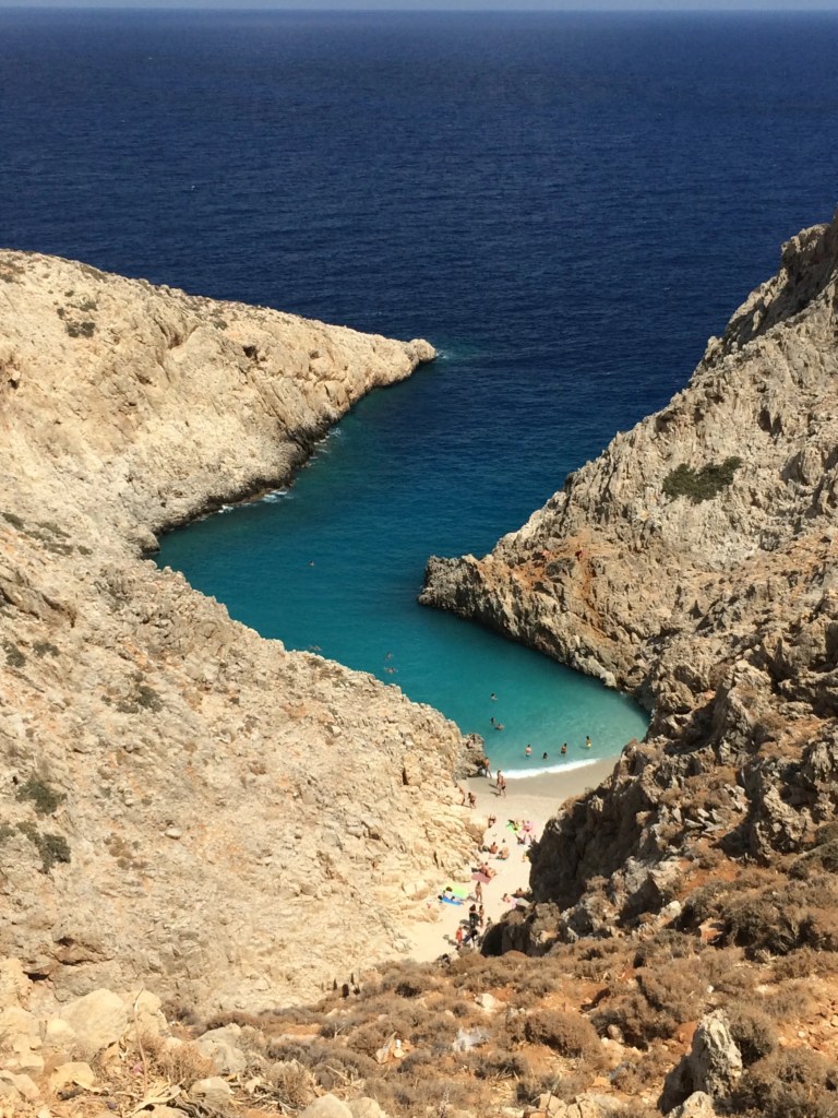 Seitan Limania widziana z góry stromego zejścia, z charakterystycznym kształtem zatoczki i turkusową wodą przy brzegu.