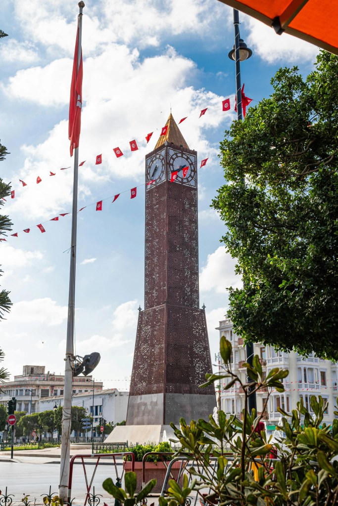 Ceglana budowla z zegarem i złotym dachom na Avenue Habib Bourguiba w Tunisie.
