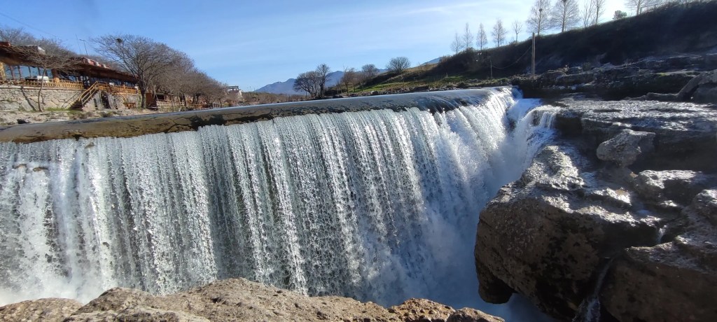 Widok czołowy na wodospad Niagara w Czarnogórze z naturalnej skalnej półki, podkreślający jego malownicze położenie.